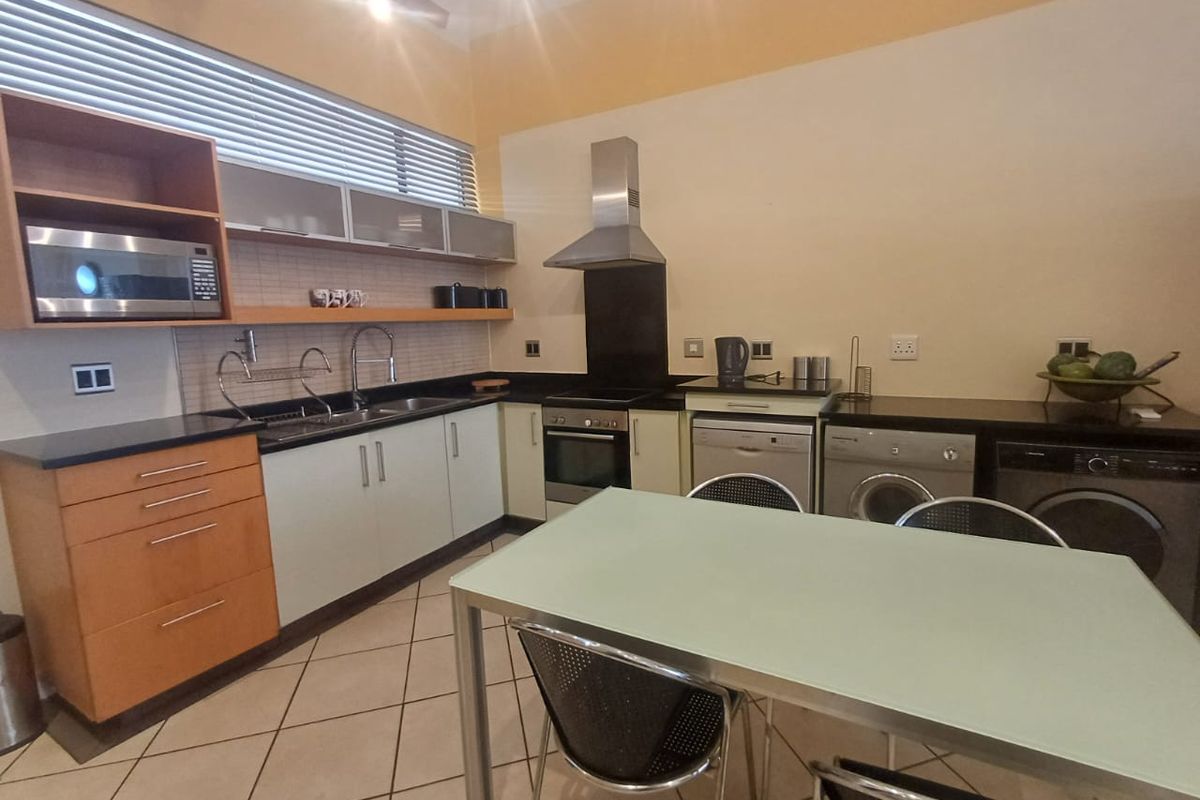 A functional kitchen featuring built-in cabinetry, granite countertops, integrated appliances, and tiled flooring, offering a practical layout for daily cooking and dining.