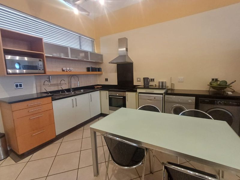 A functional kitchen featuring built-in cabinetry, granite countertops, integrated appliances, and tiled flooring, offering a practical layout for daily cooking and dining.