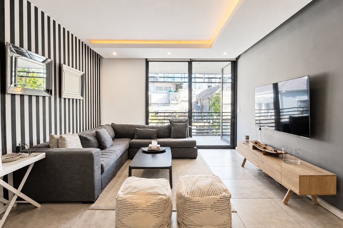 Modern living room featuring tiled floors, recessed ceiling lighting, and large sliding glass doors providing access to the balcony.