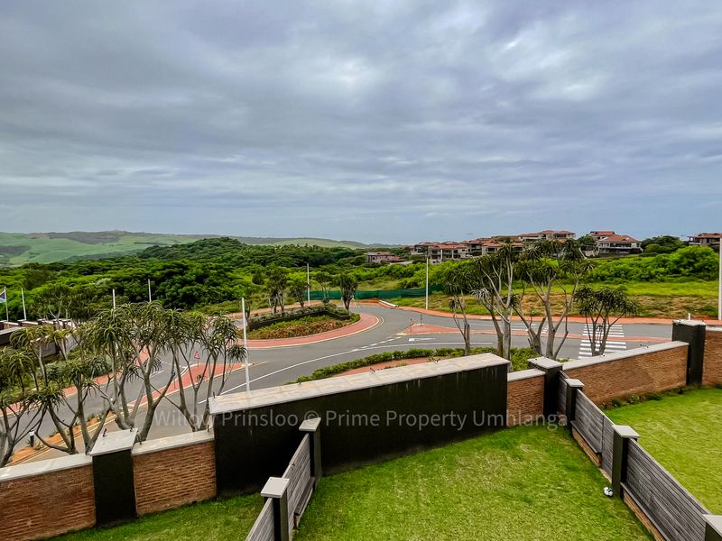 Elevated view overlooking the surrounding neighbourhood, green hills, and local road infrastructure from a private garden area.