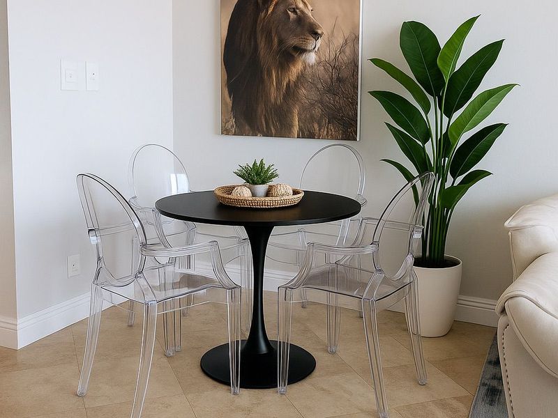 A bright dining area featuring neutral wall tones, crown molding, and durable ceramic tile flooring.