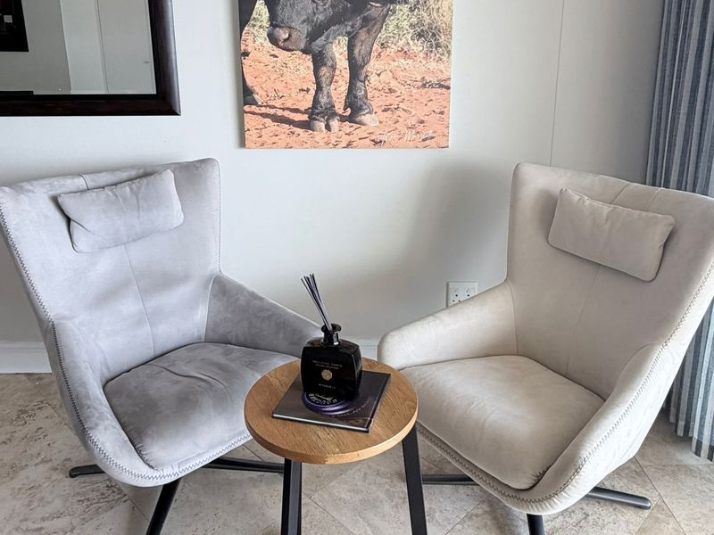 A cozy seating area featuring neutral tiled flooring and a clean, modern wall finish, suitable for a relaxed lounge or reading nook.