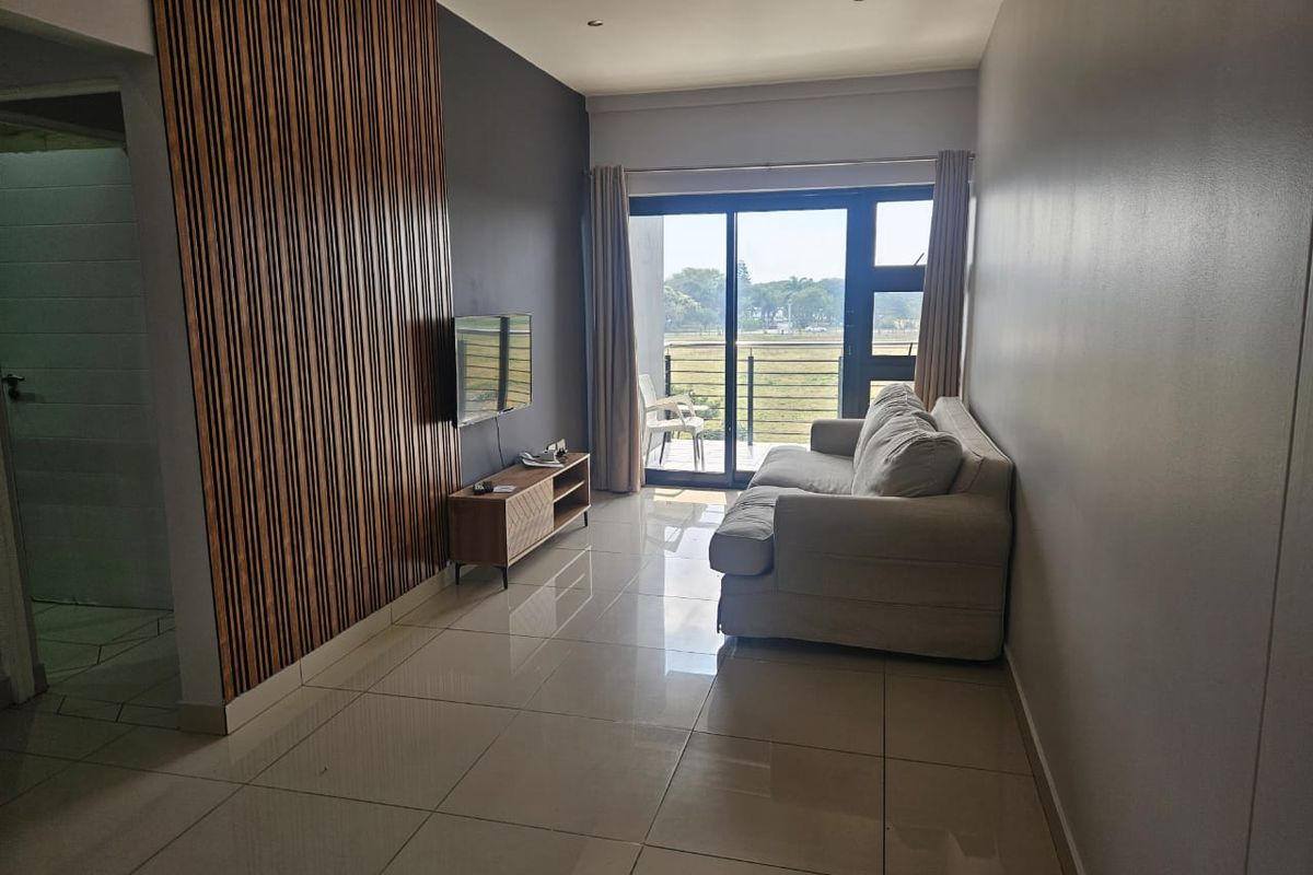 A modern living room featuring a decorative slatted wood accent wall, large format floor tiles, and a sliding door leading to an outdoor balcony.