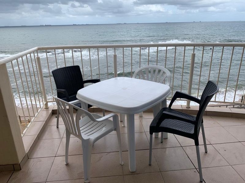 A balcony featuring tiled flooring and a metal balustrade, offering direct ocean views.