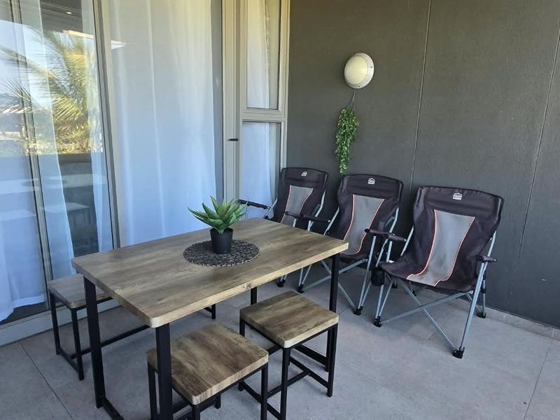 A covered balcony featuring tiled flooring and large sliding glass doors, providing a seamless transition between indoor and outdoor living spaces.