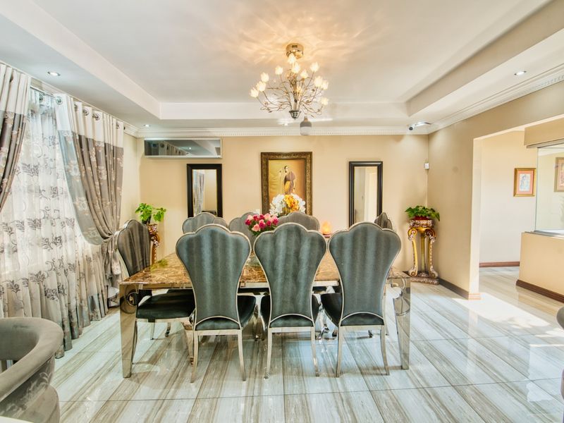Elegant dining room featuring polished tiled flooring, a decorative chandelier, recessed ceiling details, and integrated air conditioning.