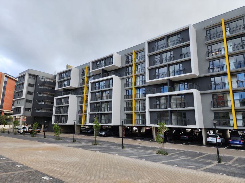 Modern multi-story apartment complex featuring contemporary architectural design, private balconies, and convenient ground-level undercover parking facilities.