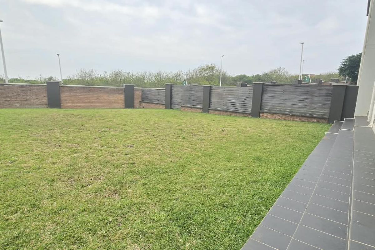 A private rear garden featuring a tiled patio area and a secure perimeter wall with timber fencing.