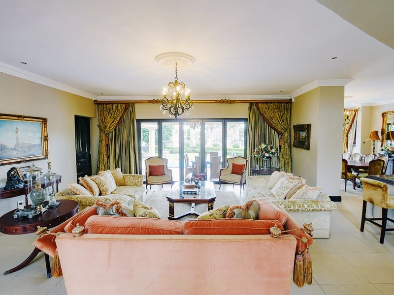 Spacious open-plan living area featuring tiled flooring, crown molding, and large sliding glass doors that provide seamless access to the outdoor patio area.