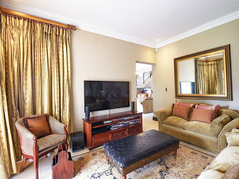 A well-maintained living room featuring decorative crown molding, recessed lighting, and an integrated air conditioning unit.