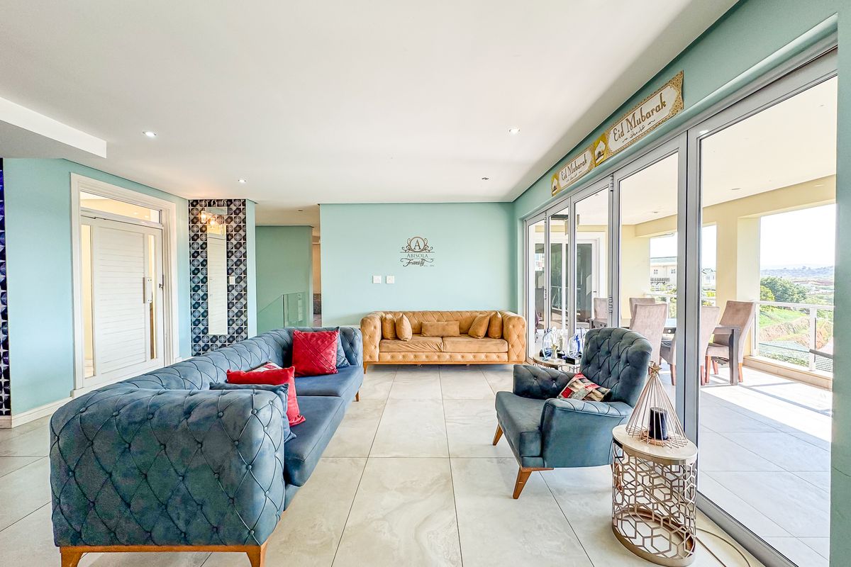 Spacious living room featuring large format floor tiles, recessed lighting, and expansive sliding glass doors that provide seamless access to the outdoor patio area.