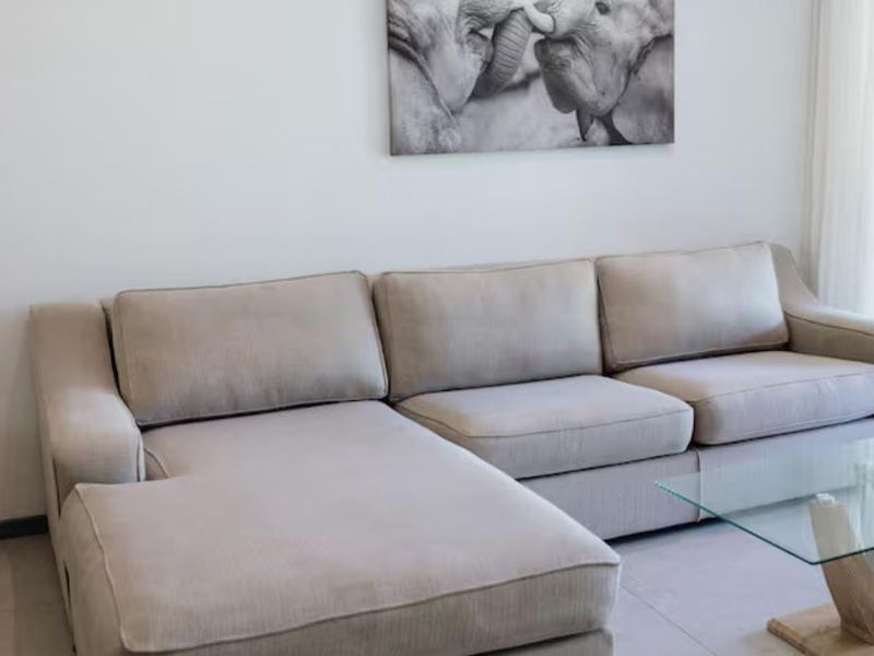 A bright and modern living room featuring neutral tiled flooring and a clean, minimalist aesthetic.