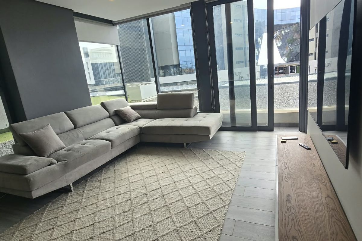 Modern living room featuring floor-to-ceiling windows, sliding glass doors leading to an outdoor area, and contemporary tiled flooring.
