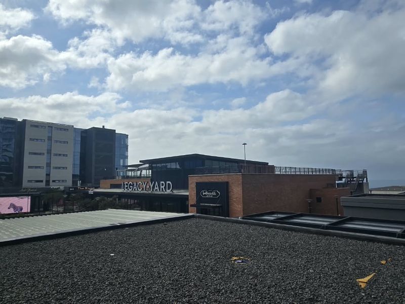 An elevated view overlooking the surrounding urban development, featuring modern glass architecture and commercial buildings.