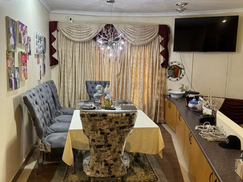 Dining area featuring built-in cabinetry with a sink, tiled flooring, and a split-system air conditioner.