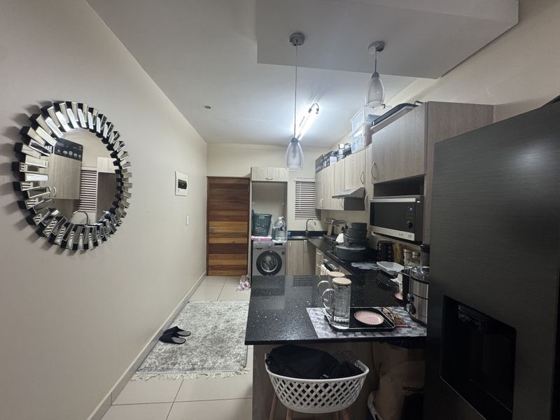 A functional kitchen featuring modern built-in cabinetry, granite countertops, integrated appliances, and stylish pendant lighting, offering a clean and efficient workspace.