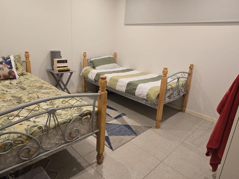 A functional bedroom featuring tiled flooring and a built-in wardrobe, providing a practical space for residents.