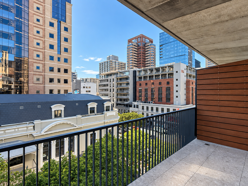 A modern balcony featuring tiled flooring, a metal balustrade, and a timber privacy screen, offering an expansive urban city view.