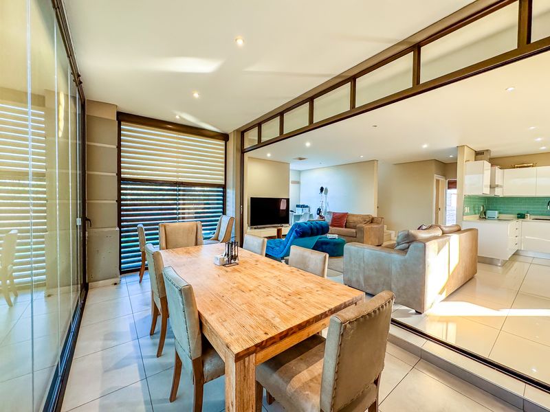 Spacious open-plan living area featuring tiled floors, recessed lighting, and a modern kitchen with integrated cabinetry and a stylish subway tile backsplash.