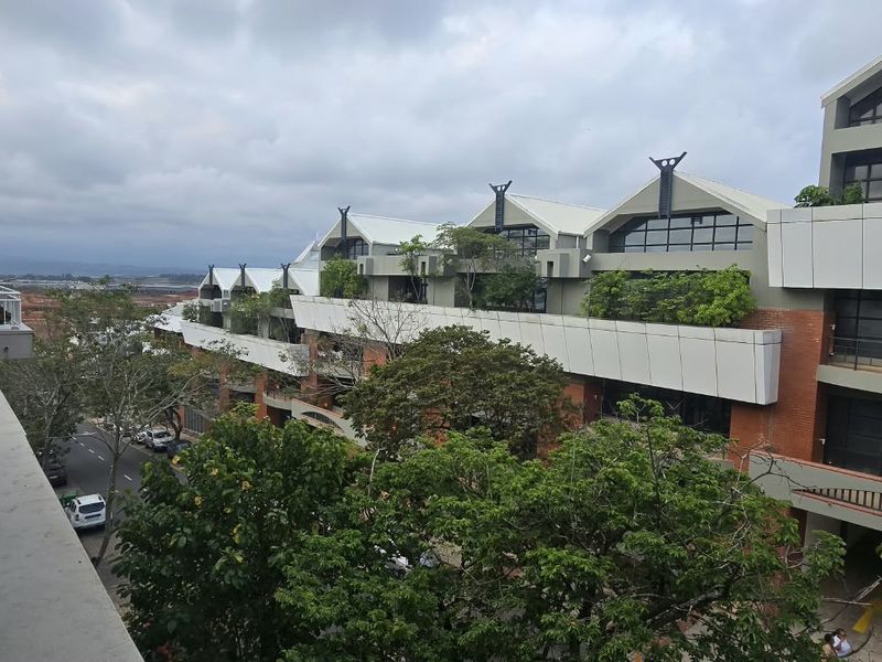 Elevated view from a balcony overlooking the apartment complex architecture and surrounding neighbourhood.