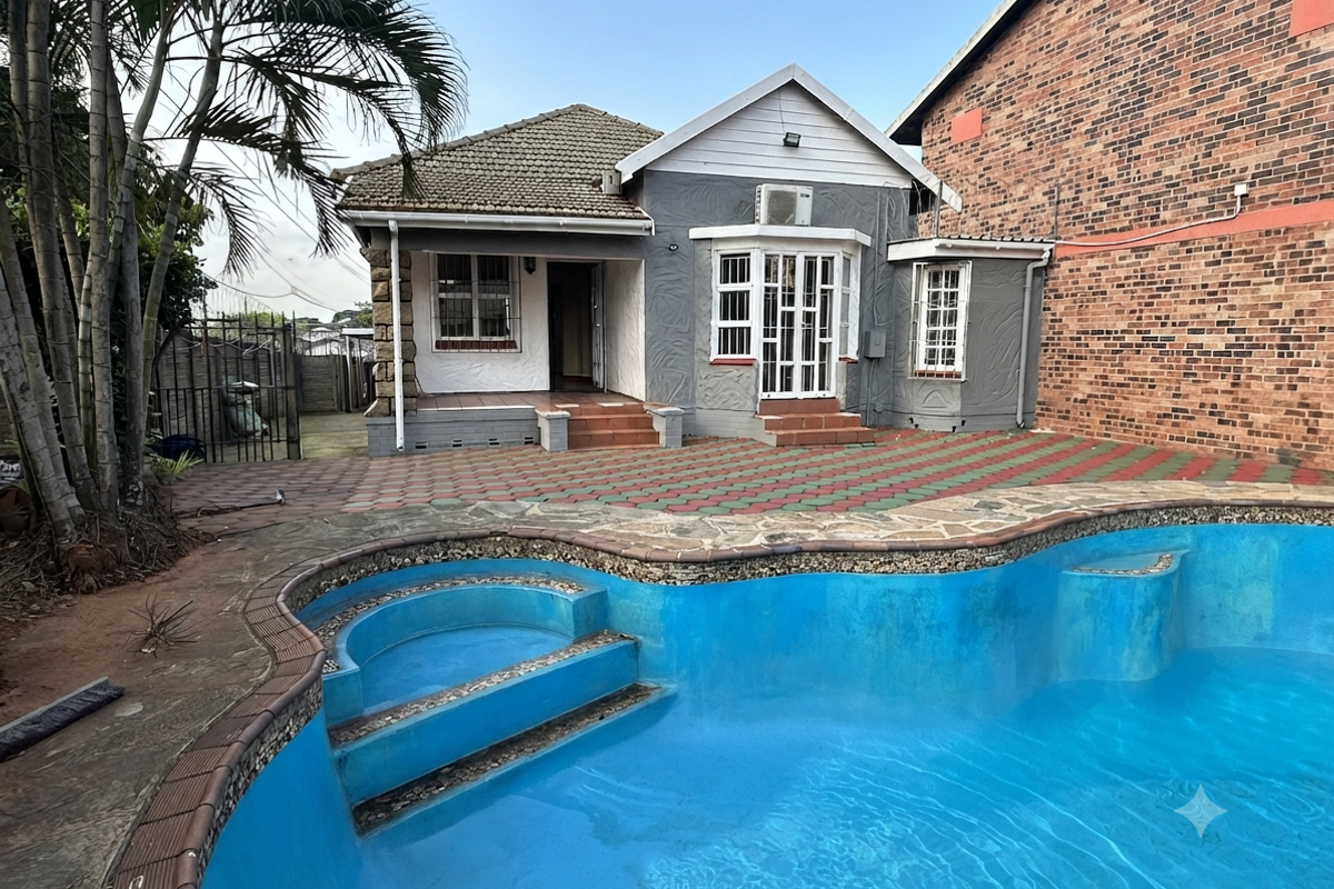 Rear view of the townhouse featuring a swimming pool, paved patio area, and exterior access to the main living space.
