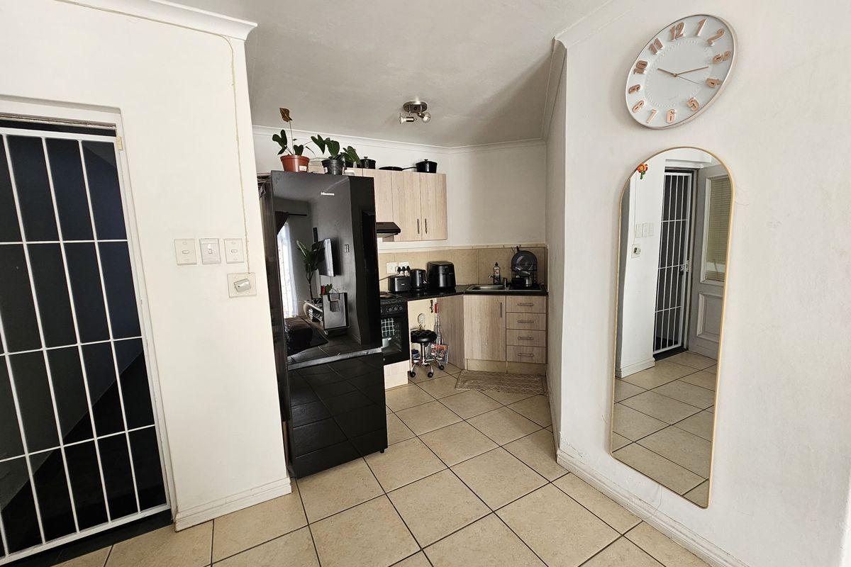 Compact kitchen area featuring built-in cabinetry, tiled flooring, and integrated appliances, providing a functional space within the apartment.