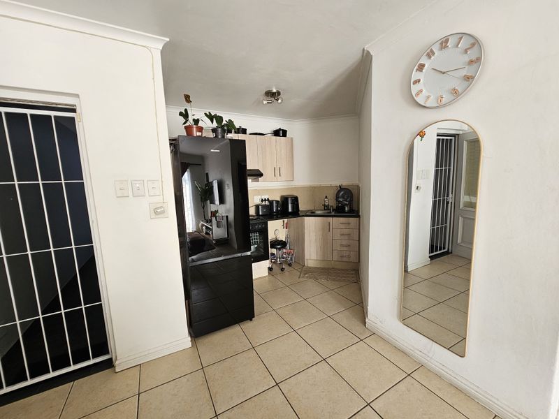 Compact kitchen area featuring built-in cabinetry, tiled flooring, and integrated appliances, providing a functional space within the apartment.