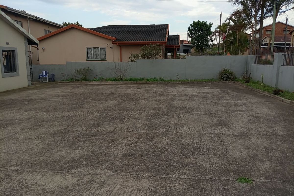 A spacious, paved rear courtyard area enclosed by a perimeter wall, offering potential for landscaping or outdoor entertainment development.