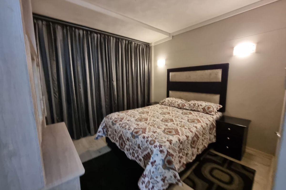 A bedroom featuring wall-mounted light fixtures and neutral wall finishes, providing a comfortable and functional sleeping space.