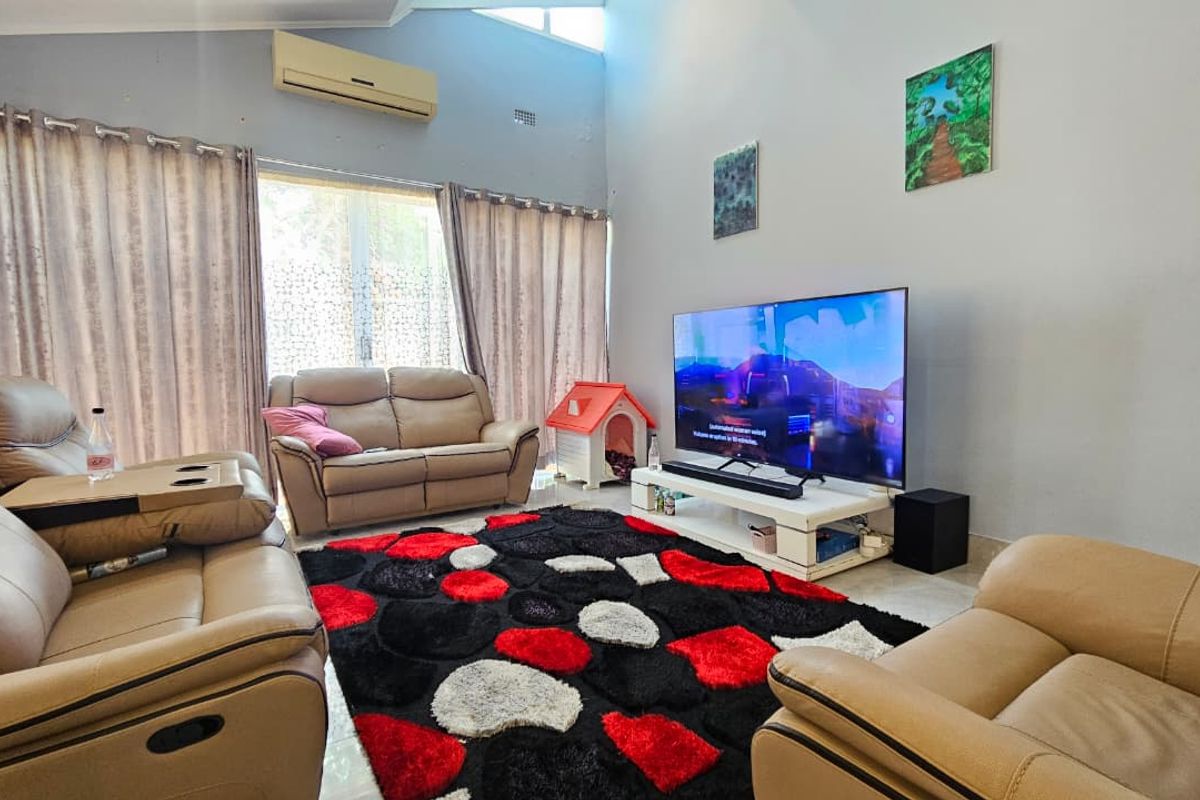 Spacious living room featuring high vaulted ceilings, large sliding glass doors for natural light, and a wall-mounted air conditioning unit.