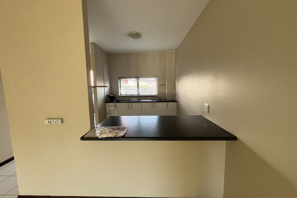 A functional kitchen featuring a breakfast bar counter, built-in cabinetry, and a window providing natural light.