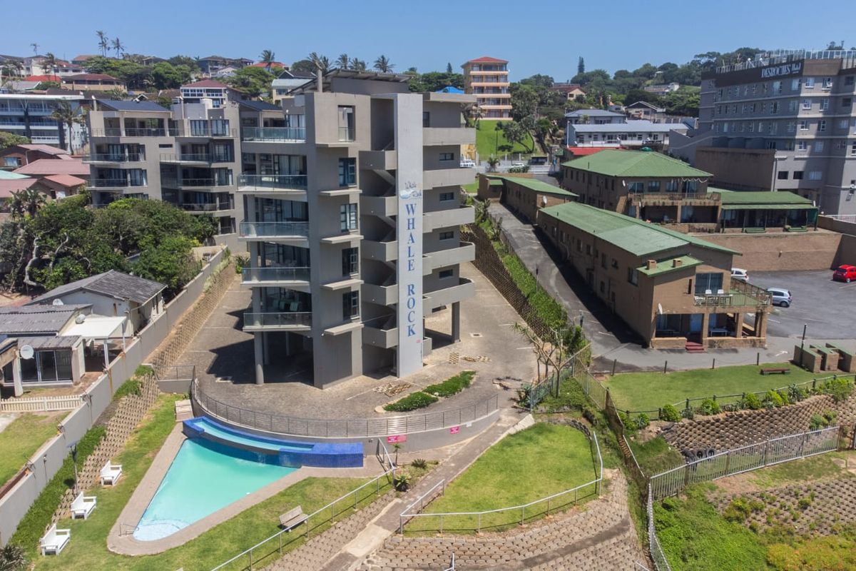 Aerial view of the Whale Rock apartment complex featuring a swimming pool, landscaped grounds, and multi-level balconies.