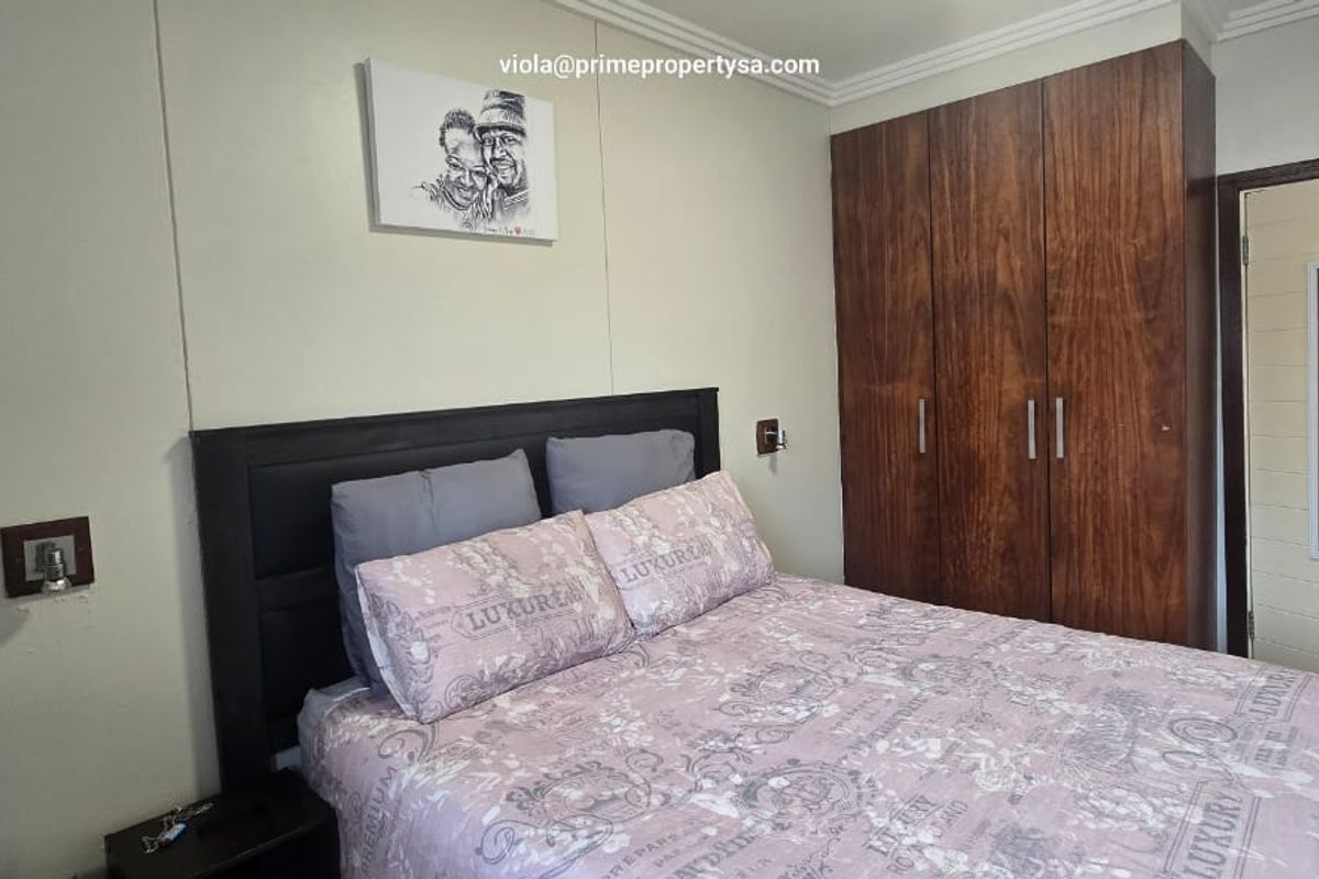 A bedroom featuring a built-in wooden wardrobe and a standard internal door.