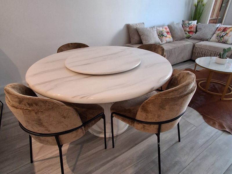 An open-plan living and dining area featuring modern light-toned laminate flooring and a neutral color palette.