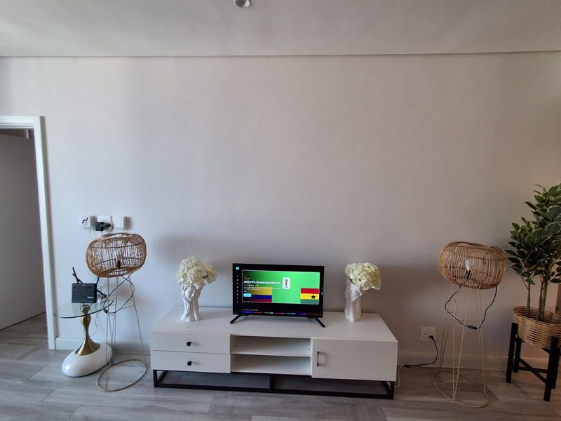 A bright living room area featuring neutral tiled flooring and clean wall finishes, providing a versatile space for entertainment and relaxation.