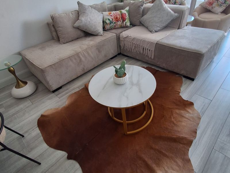 A bright and modern living room featuring light-toned tiled flooring and large sliding glass doors that provide ample natural light.