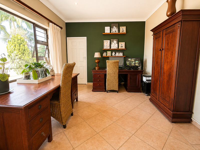 A well-lit home office featuring tiled flooring, large windows with natural light, and a dedicated workspace area.