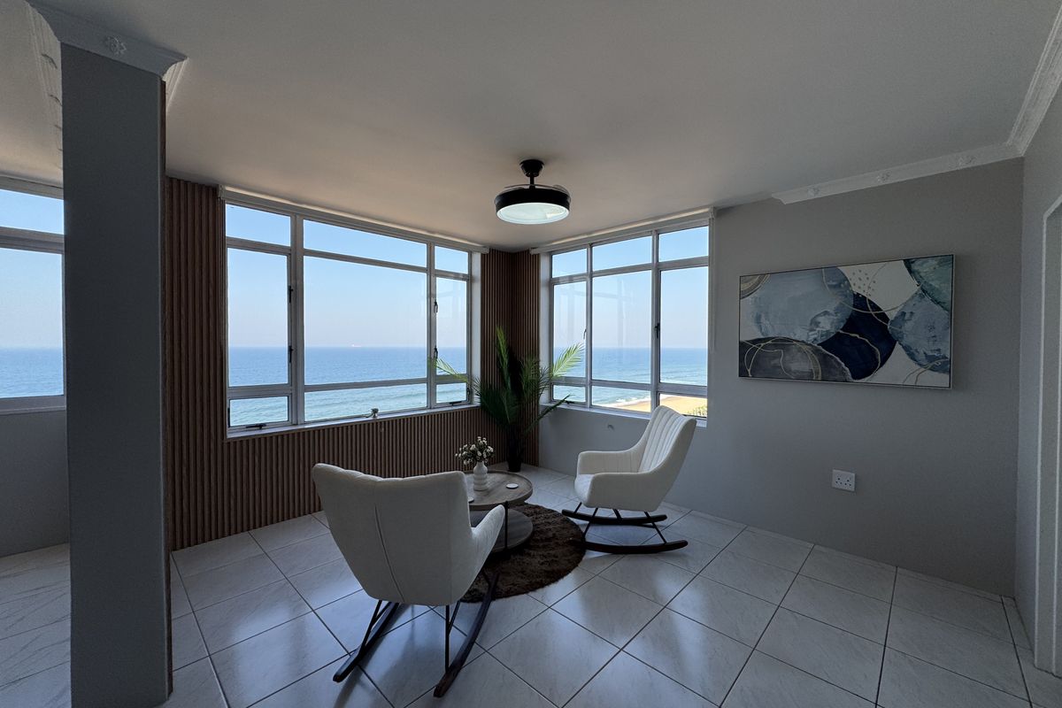 A bright living area featuring large windows with panoramic ocean views, tiled flooring, and modern slatted wall paneling.