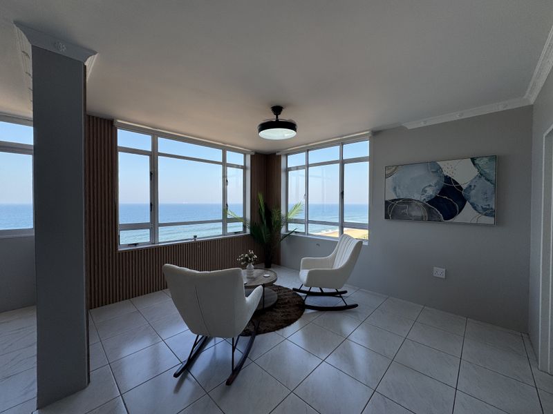 A bright living area featuring large windows with panoramic ocean views, tiled flooring, and modern slatted wall paneling.