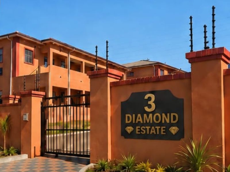 Front entrance view of Diamond Estate featuring a secure gated access point, masonry boundary walls, and electric fencing.