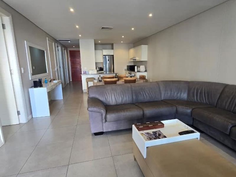 Spacious open-plan living area featuring tiled flooring, recessed lighting, ducted air conditioning, and a functional kitchen with built-in cabinetry.