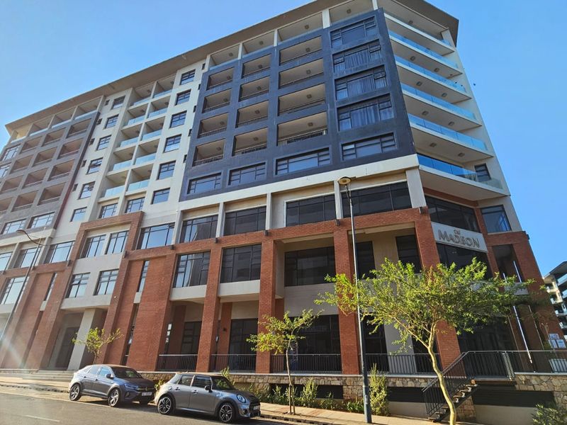 A modern multi-story apartment building featuring a brick and glass facade with private balconies and street-level commercial access.