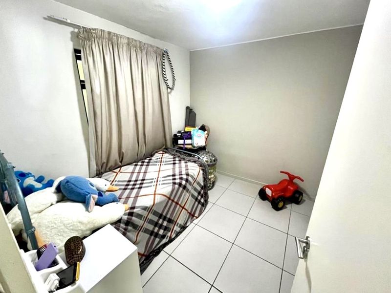 A compact bedroom featuring neutral wall finishes and tiled flooring, providing a functional space with natural light from the window.
