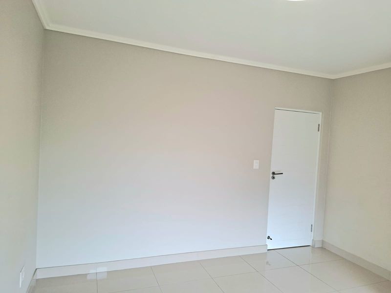 A clean, neutral, and empty bedroom featuring modern tiled flooring and crisp white finishes, ready for personalization.