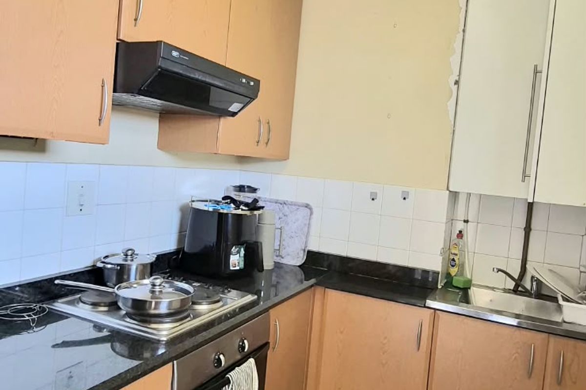 Functional kitchen featuring laminate cabinetry, granite countertops, built-in oven, electric hob, and tiled flooring. The space offers a practical layout for daily meal preparation.
