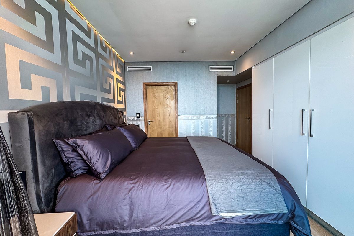A well-maintained bedroom featuring built-in wardrobes, recessed ceiling lighting, and integrated ducted air conditioning vents.