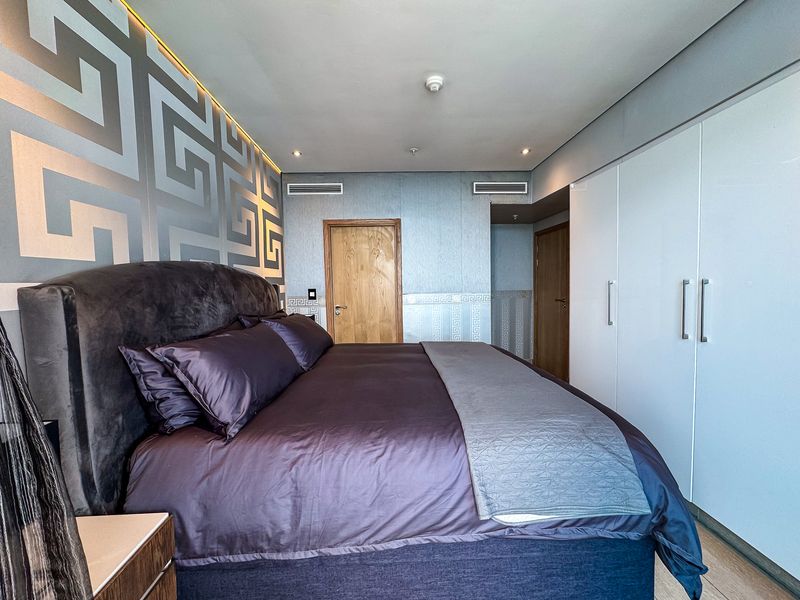 A well-maintained bedroom featuring built-in wardrobes, recessed ceiling lighting, and integrated ducted air conditioning vents.