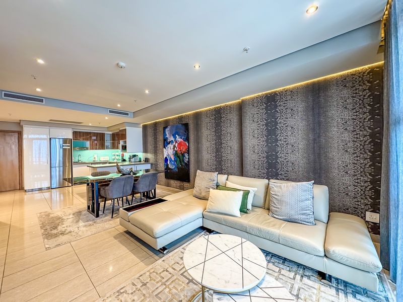 Modern open-plan living area featuring tiled floors, recessed lighting, ducted air conditioning, and a sleek integrated kitchen with contemporary finishes.