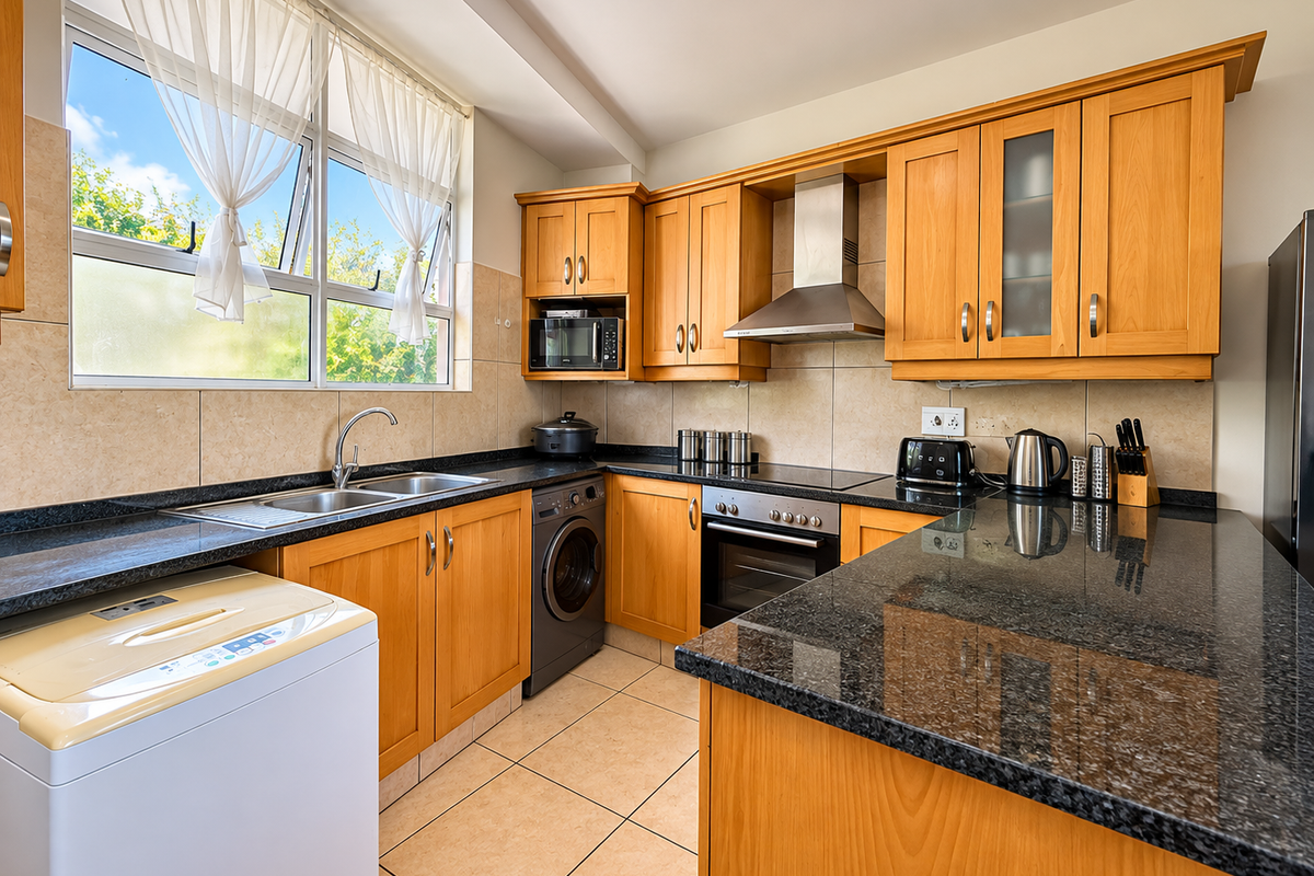 A functional kitchen featuring warm wooden cabinetry, granite countertops, a built-in oven with extractor fan, and tiled finishes throughout.