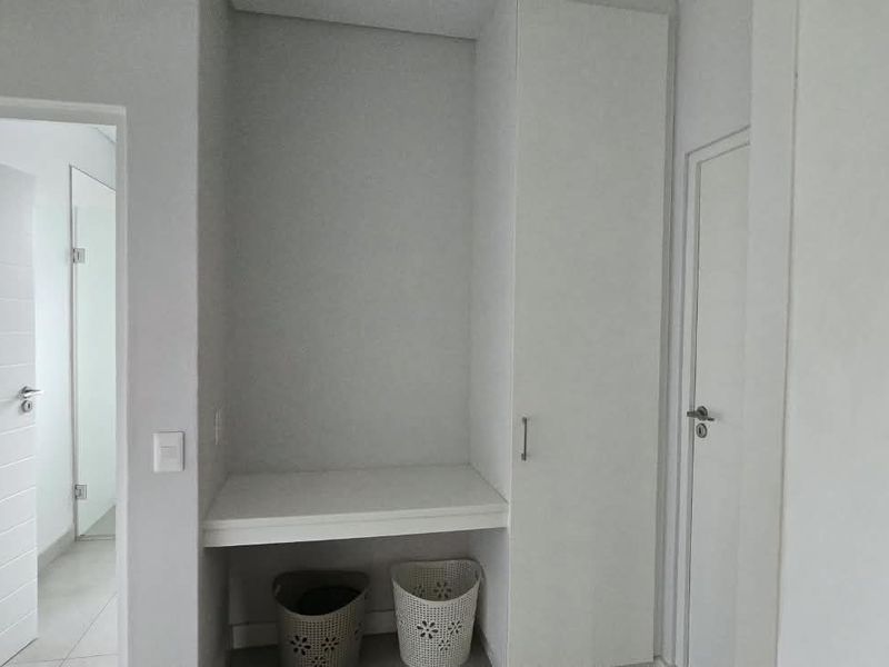 A clean and functional laundry or utility space featuring built-in cabinetry and a dedicated workspace area.
